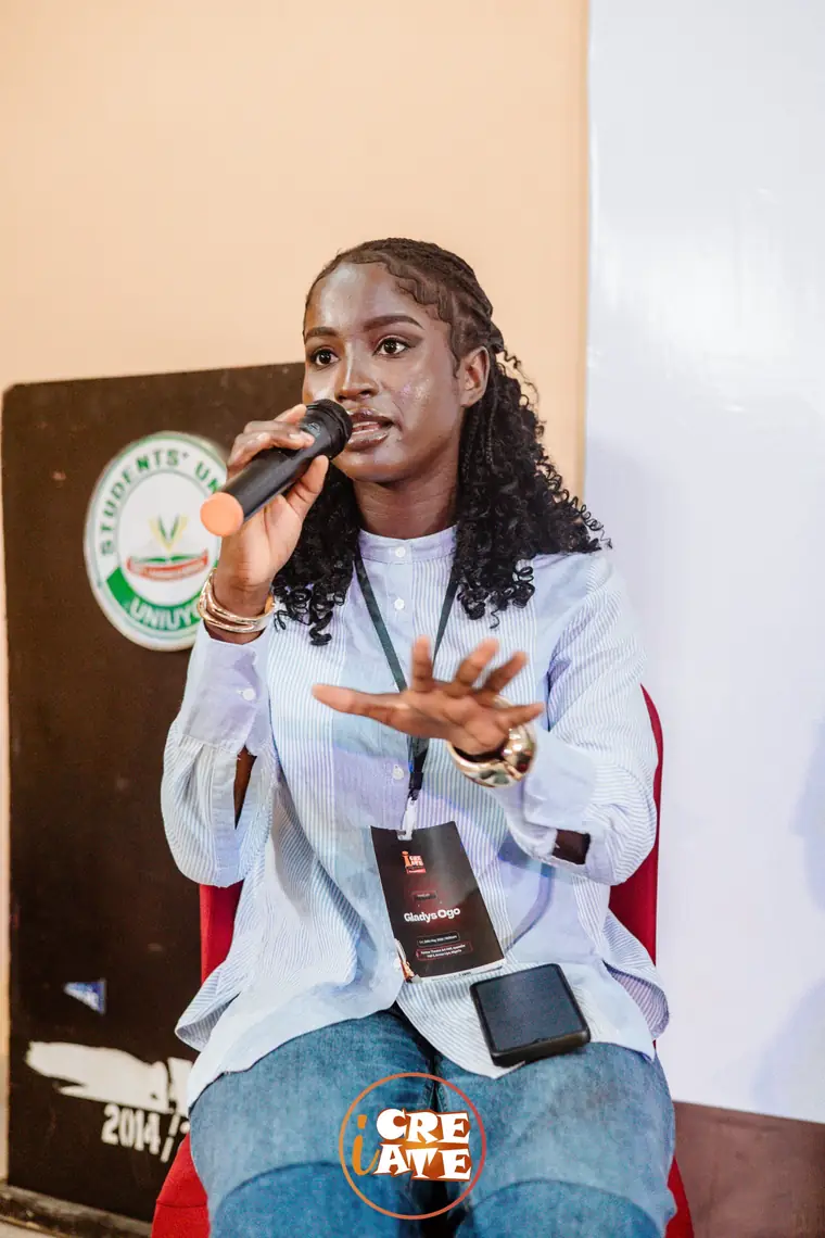 Gladys Ogo speaking into a microphone as a panelist at the iCreate Conference in Uyo